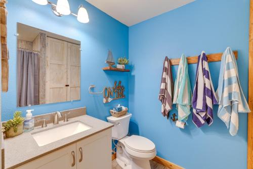 uma casa de banho com paredes azuis e um WC e um lavatório. em Lakefront Shell Knob Condo with Deck and Grill! em Shell Knob