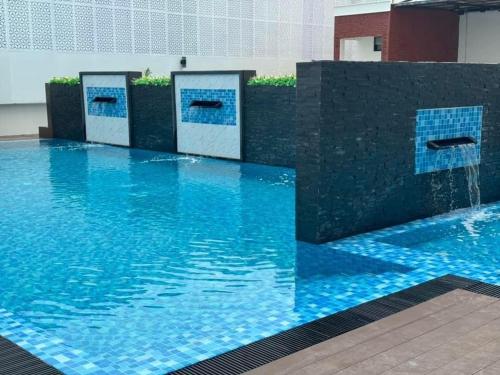 a swimming pool with blue water in a building at Remas Hotel Hatyai in Hat Yai