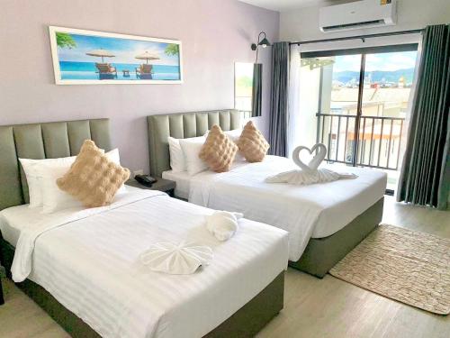 a hotel room with two beds and a balcony at Remas Hotel Hatyai in Hat Yai