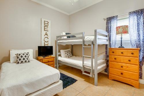 een slaapkamer met 2 stapelbedden en een televisie bij South Padre Island Condo - Walk to the Beach! in South Padre Island