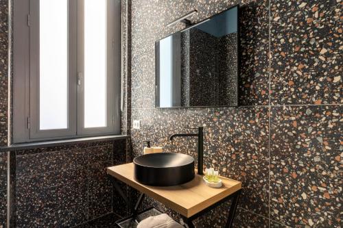 a bathroom with a black sink and a mirror at Residenza '900 in Castellanza