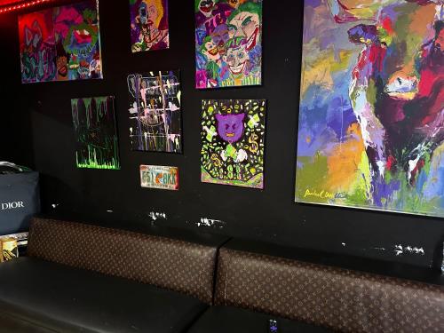 a wall with paintings on it with a couch at The Black Door miami in Miami