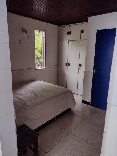sypialnia z łóżkiem i oknem w obiekcie Suíte Lazuli w mieście Itaparica