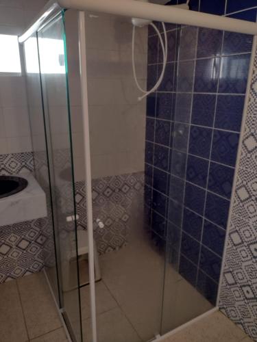 W łazience znajduje się prysznic ze szklanymi drzwiami. w obiekcie Suíte Lazuli w mieście Itaparica