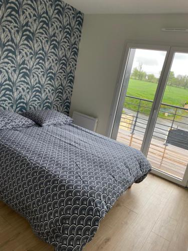 a bedroom with a bed and a large window at A 15km du Mont-Saint Michel in Saint-James