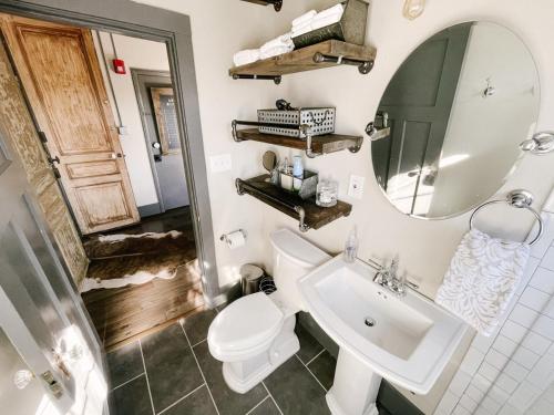 a bathroom with a sink and a toilet and a mirror at Neyland View Condo - Heart of Downtown Knoxville in Knoxville