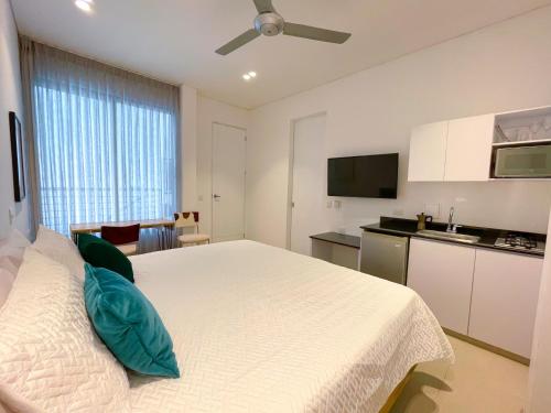 Schlafzimmer mit einem weißen Bett und einem Deckenventilator in der Unterkunft Apartaestudio Brumilo 1 in Montería