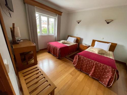 a room with two beds and a window at Solar S.Bento in Santo Tirso