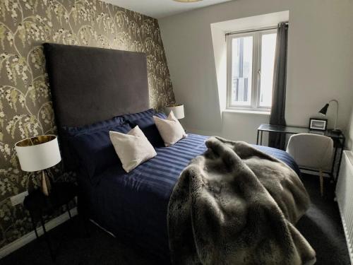 a bedroom with a bed with a blanket on it at Edward St Apartments in Belfast