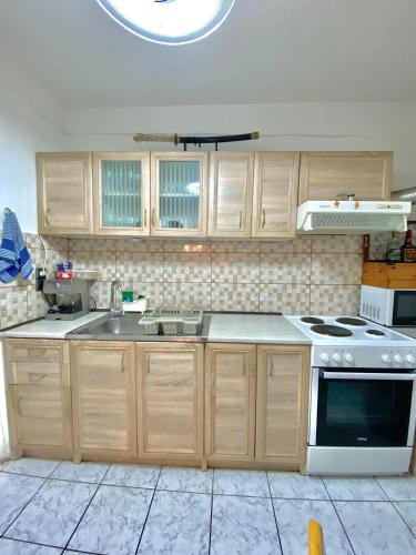 a kitchen with wooden cabinets and a white stove top oven at Aggelina in Sárkhos