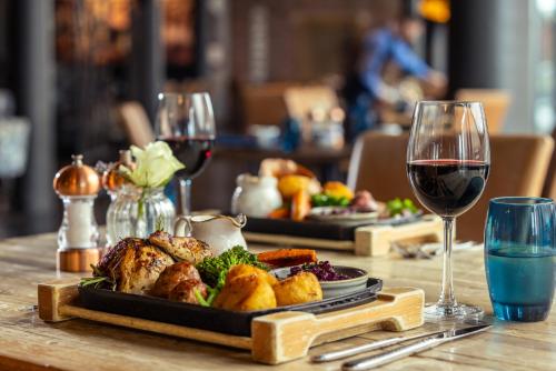 a table with two plates of food and wine glasses at Titanic Hotel Liverpool in Liverpool
