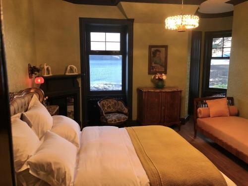 a bedroom with a bed and a couch and windows at Ardrhu House Fort William - Superior Room in Fort William