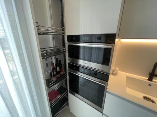 an empty refrigerator with two ovens in a kitchen at Haus Margarete - Attico Infinity Vista Mare con Jacuzzi - Agenzia Cocal in Caorle