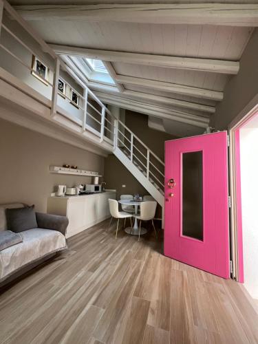 een woonkamer met een roze deur en een tafel bij Vanessa Home in Burano