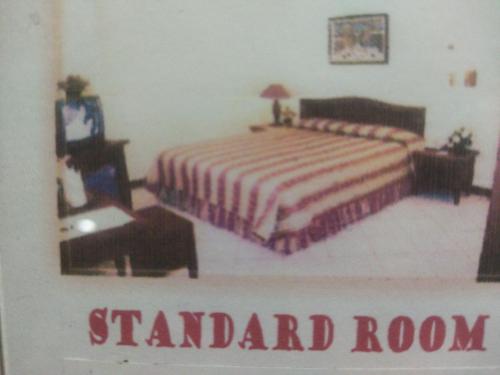 1 dormitorio con 1 cama, 1 silla y 1 mesa en Hotel Anging Mammiri, en Makassar