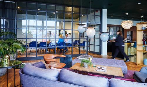un soggiorno con divani blu e un tavolo di Hotel Jutlandia a Frederikshavn