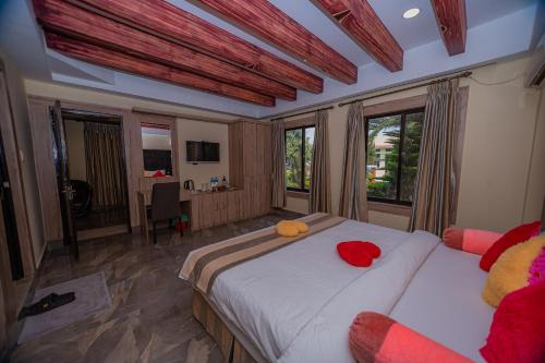Un dormitorio con una cama con almohadas rojas. en Hotel Seven Star, en Sauraha