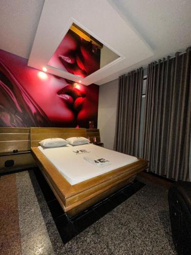 um quarto com uma cama com um quadro na parede em Motel Vitoria Reggia em São Vicente