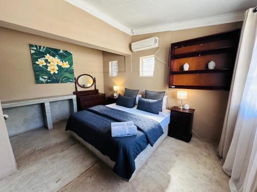 a bedroom with a bed with a blue comforter at 49 on Main: A Spacious Self Catering Guesthouse in Sabie