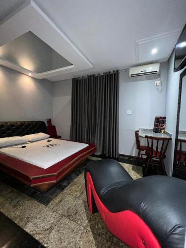 Motel Vitoria Reggia في ساو فيسينتي: غرفة نوم بسرير واريكة وطاولة