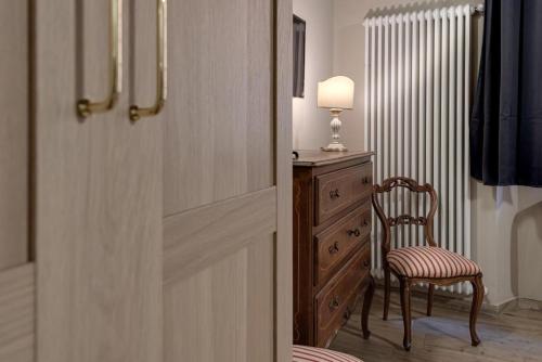 una porta che conduce a una stanza con una sedia e un comò di NETTUNO LUXURYH - BOLOGNACENTRO Duomo Rooms and suites a Bologna