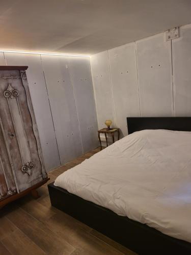 a bedroom with a bed and a white wall at Duinenbank in Bredene