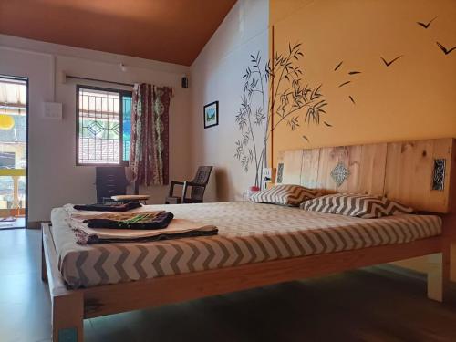 a bedroom with a large bed with birds on the wall at Sai Homestay in Malvan