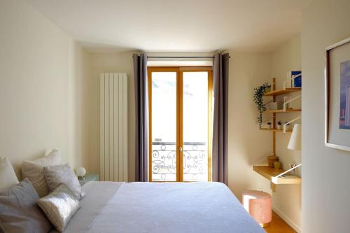 - une chambre avec un lit et une porte donnant sur un balcon dans l'établissement Apt Opéra-Richelieu/Heart of Paris, à Paris