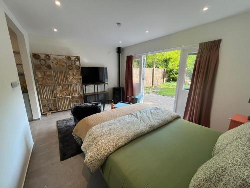 a bedroom with a bed and a sliding glass door at Huisje Teak in Beekbergen