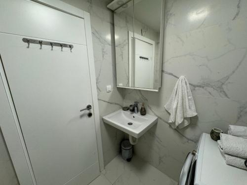 un bagno bianco con lavandino e doccia di Front Row Sunset a Rafailovici