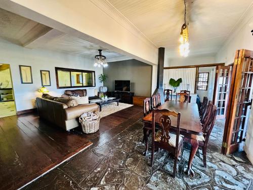 a living room with a table and a couch at 49 on Main: A Spacious Self Catering Guesthouse in Sabie