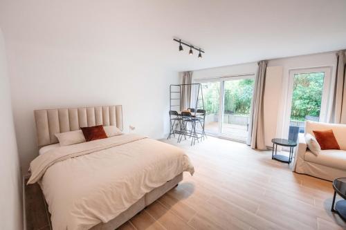 a white bedroom with a bed and a couch at K-suites in Brussels