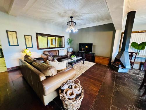 a living room with a couch and a fireplace at 49onMain Self Catering Holiday Home in Sabie