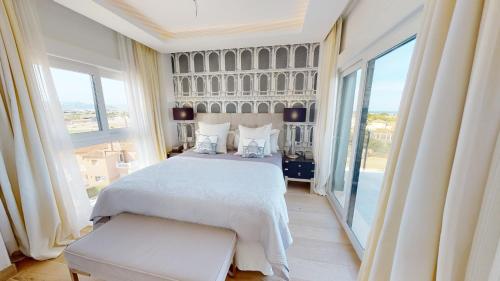 a bedroom with a white bed and a large window at Atico Serenity by Oliva Nova in Oliva