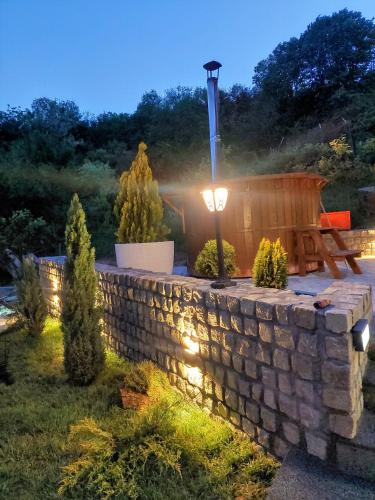 a stone wall with a hot tub in a yard at Vila MP Banstol 4*- Brdež do, Fruška gora in Inđija