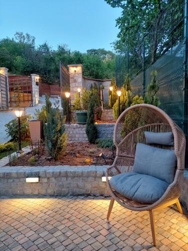 a wicker chair with a blue pillow sitting on a patio at Vila MP Banstol 4*- Brdež do, Fruška gora in Inđija