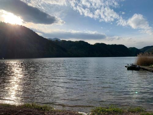 una vista su un lago con il sole che riflette sull'acqua di Mi'Ele Apartments a Pergine Valsugana