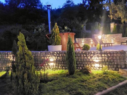 a retaining wall with lights in a garden at night at Vila MP Banstol 4*- Brdež do, Fruška gora in Inđija