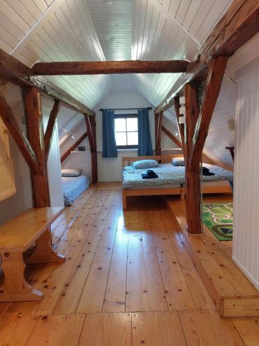 a room with two beds and a wooden floor at Martin's Family Cottage in Šmarje pri Jelšah