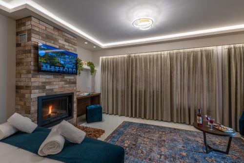 a living room with a fireplace and a tv at FLOARA DI MUNTE Forest Luxury Suites in Metsovo