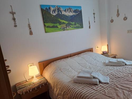ソンドリオにあるVALTELLINA SONDRIO HOLIDAYSのベッドとタオル2枚のある寝室