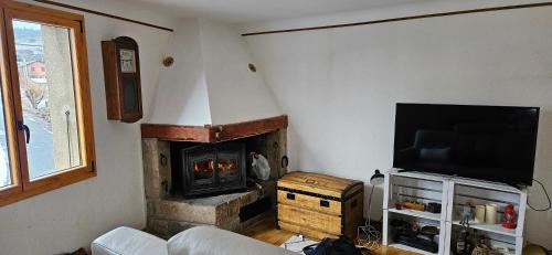un salon avec une cheminée et une télévision dans l'établissement Appartement 3 chambres à la LLagonne, à La Llagonne