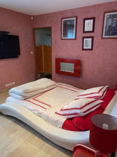 a large bed in a room with a red wall at DIVO in Trans-en-Provence