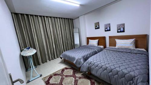 een slaapkamer met 2 bedden en een raam bij Chez-moi in Sfax