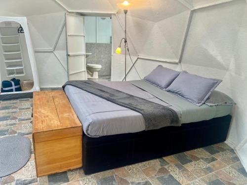 Un dormitorio con una cama con almohadas moradas. en Yaque Glamping, en San Francisco
