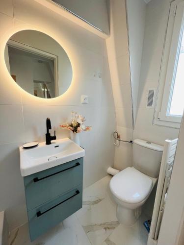 une salle de bain avec un lavabo, des toilettes et un miroir dans l'établissement Dream Dwell Paris - Apart super 150m de Centre Pompidou, à Paris