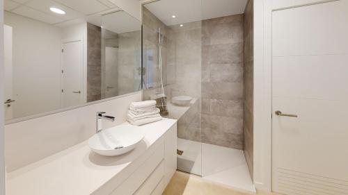 a white bathroom with a sink and a shower at Edelweiss by ON Travel in Oliva