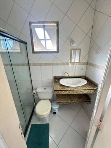 a bathroom with a toilet and a sink and a mirror at Casa inteira Labirinto in Saquarema