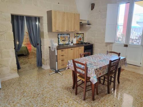 a kitchen with a table and chairs and a kitchen with a table and a counter at Casetta Abbrazio in Giuggianello