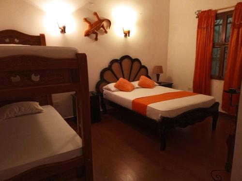 una camera con 2 letti a castello e un letto con cuscini arancioni di Hotel Viajero Mompox a Mompós